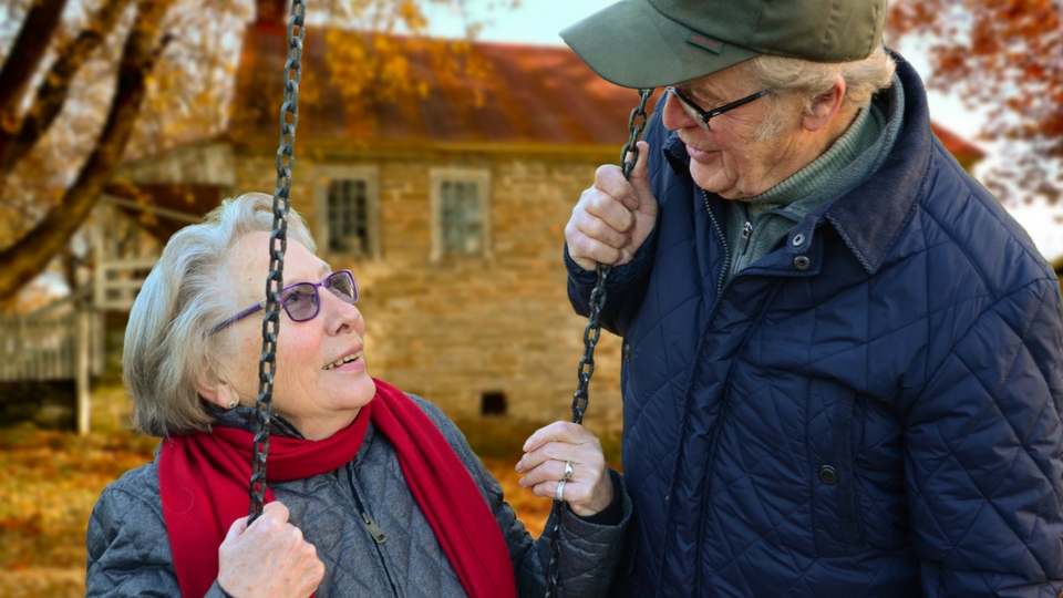 elderly couple sitting on a swing