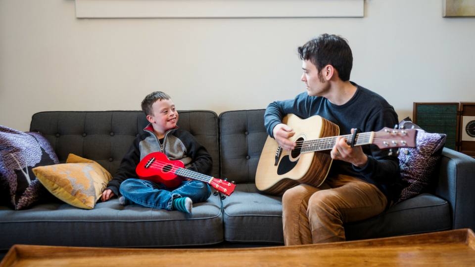 music therapist and child playing guitar