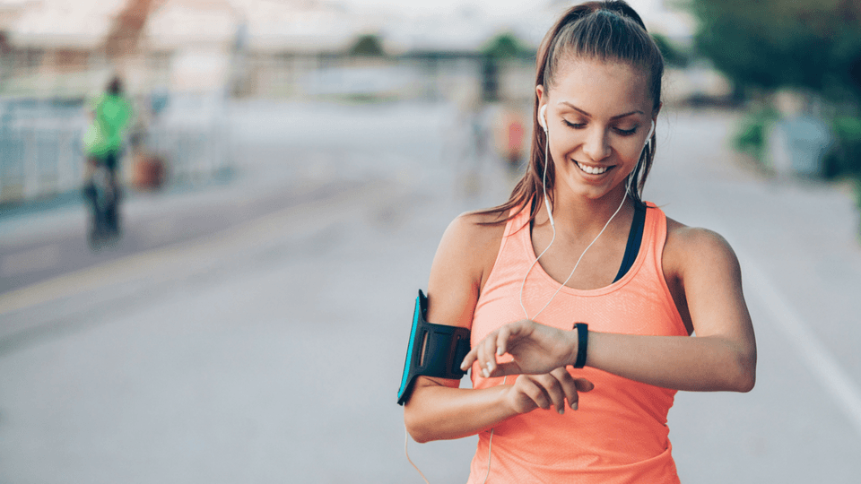 woman runner looking at her fitbit