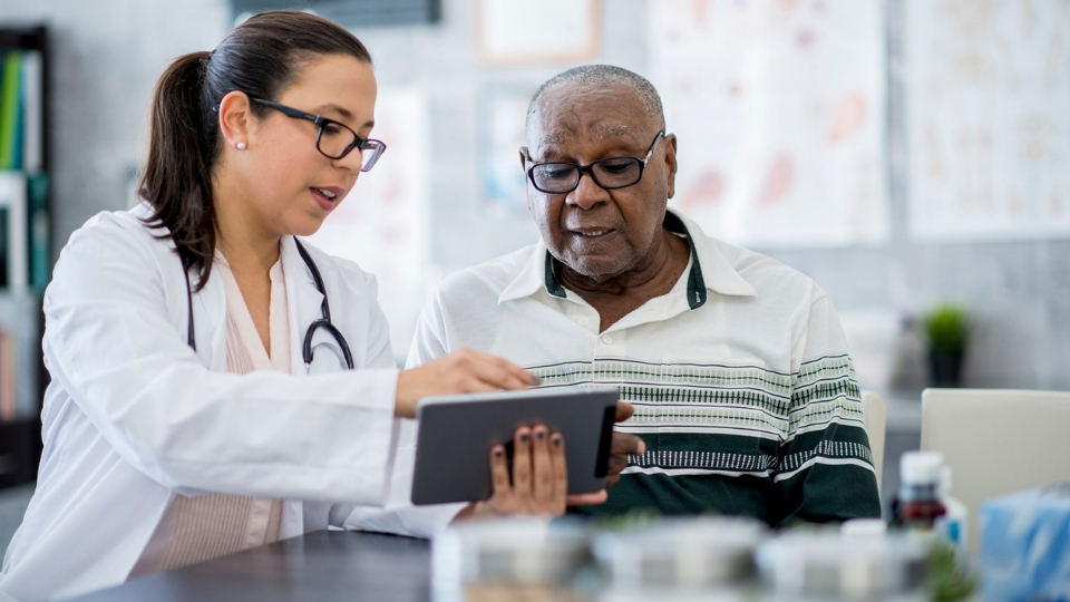 doctor explaining heart condition to elderly patient