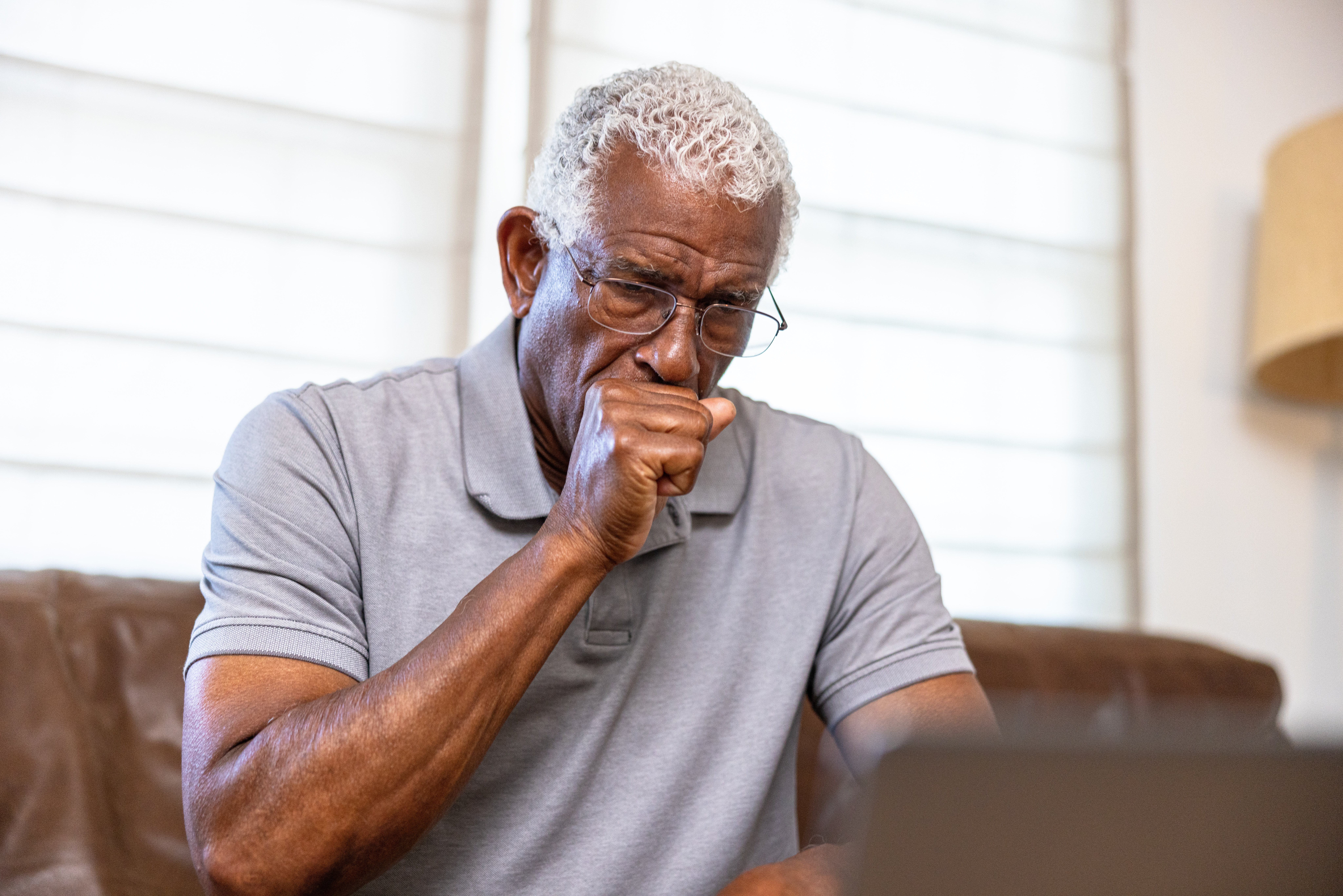 an older man is shown covering his mouth with chronic cough warning signs including chest pain and shortness of breath