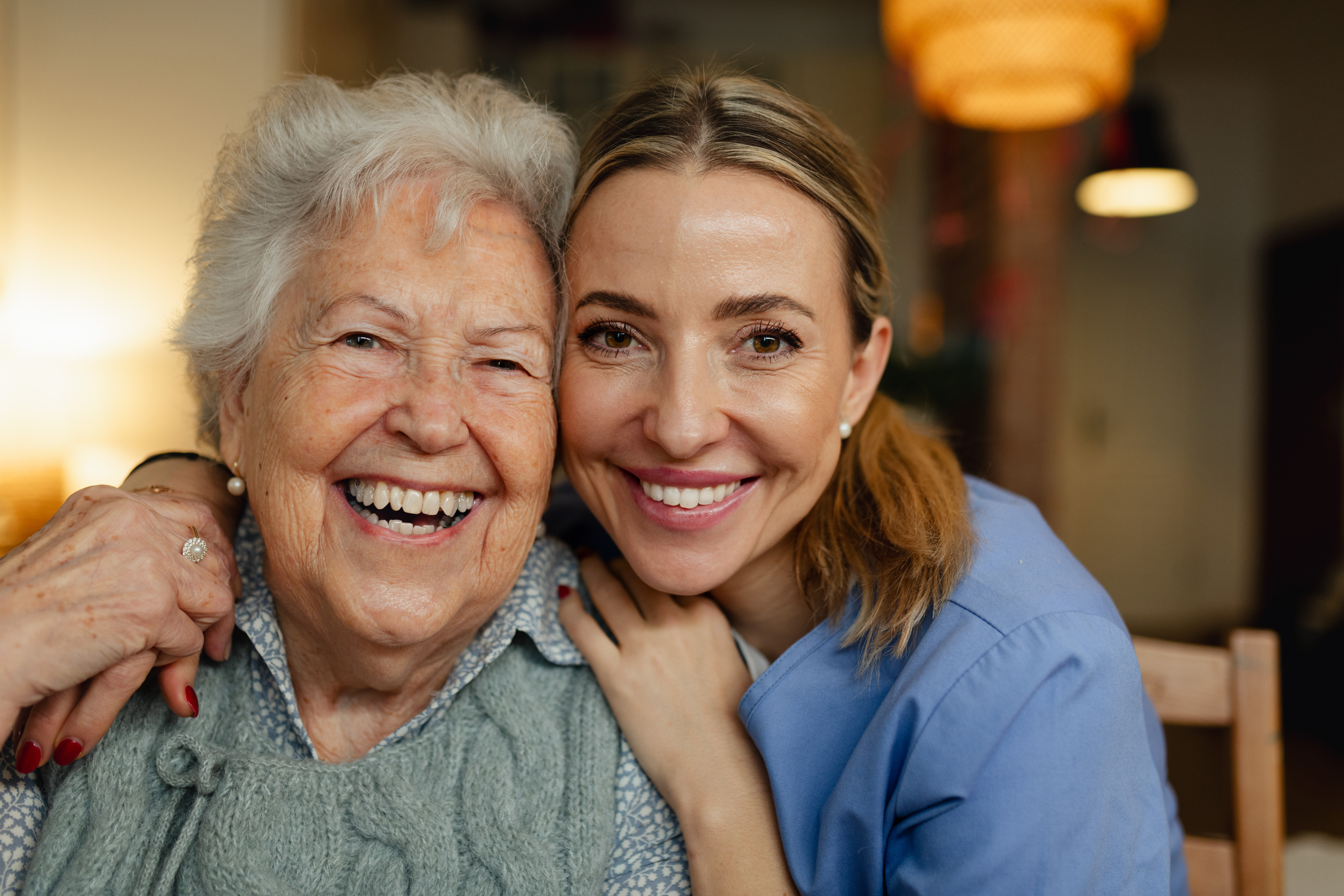 an older woman and her caregiver smiling